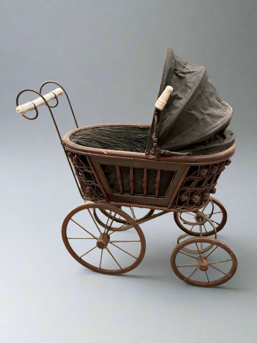 Antique Victorian toy pram/carriage with a decorative wooden frame, circa late 1800s.