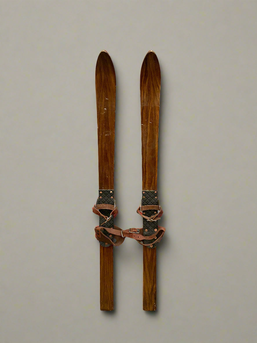 A pair of short thin wooden vintage skis.