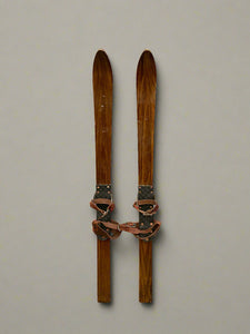 A pair of short thin wooden vintage skis.