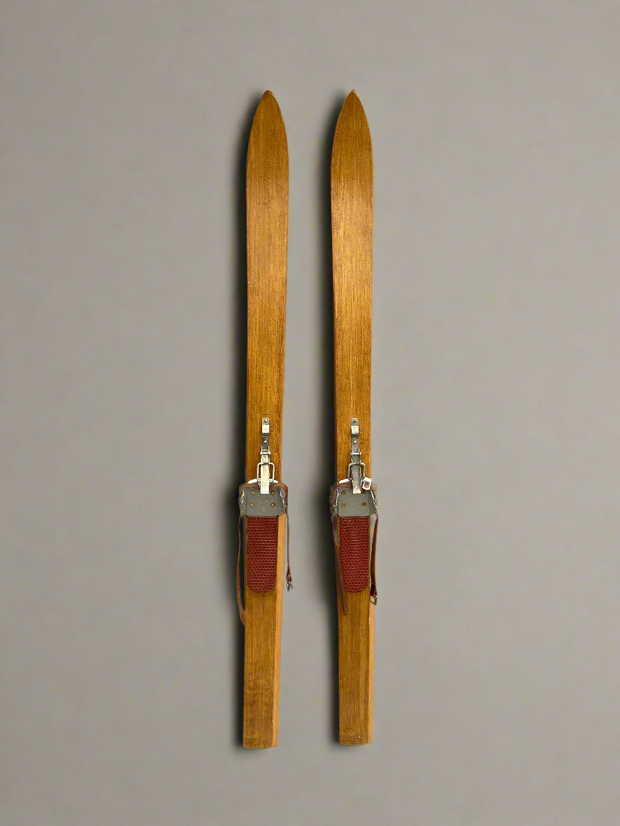 A pair of short vintage skis, crafted from light wood.