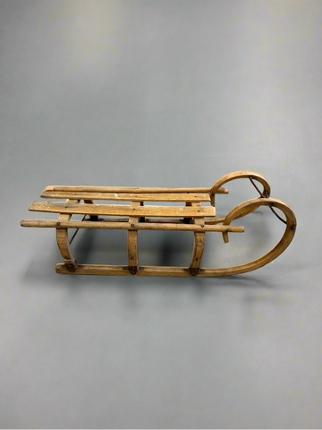 Shorter antique wooden sledge with a curved 'ram's horn' front.