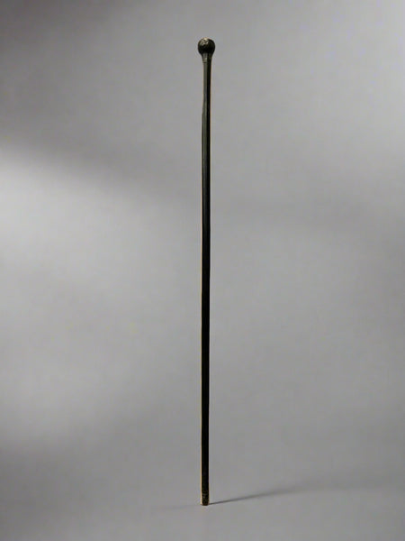 A sleek ebonised walking stick with a black metal ball top.