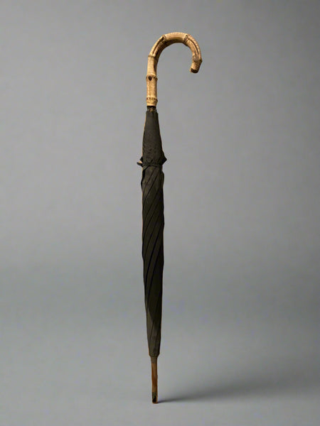 A set of classic black umbrellas with thick whangee bamboo crook handles.