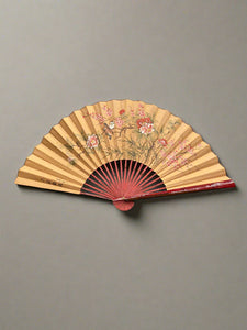 A traditional Asian folding paper fan, with a hand-painted chinoiserie style design.