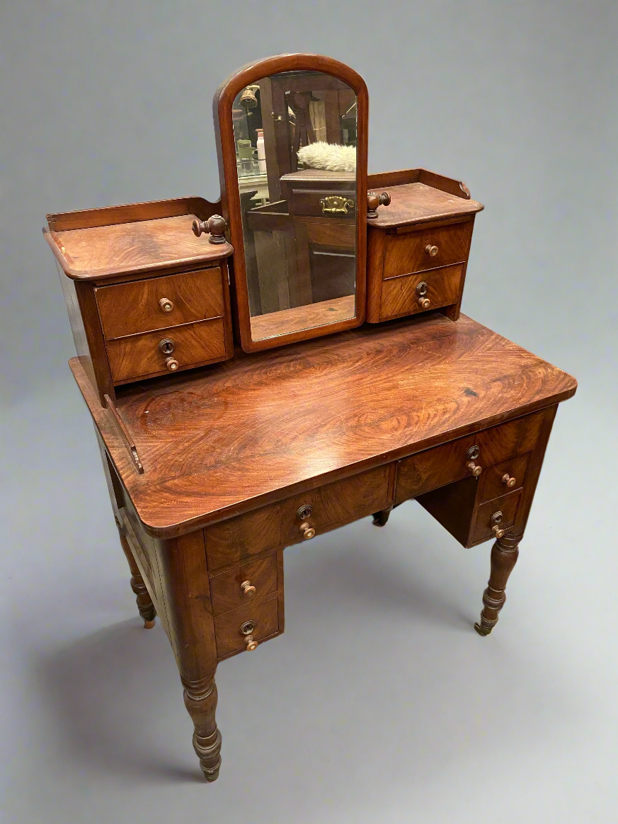 A Victorian mahogany dressing table with a central adjustable mirror and 10 drawers.