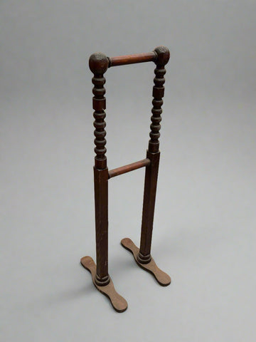 A matching pair of antique wooden towel rails with turned bobbin supports.