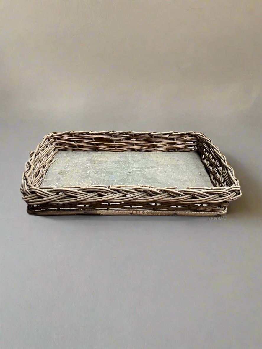 A rustic basket tray made from woven rattan, for storing papers.