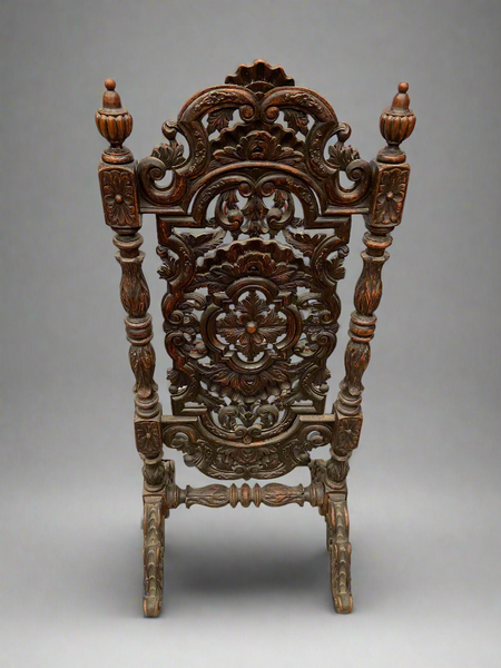 An ornately carved wooden Victorian fire screen, in a gothic revival style. The middle section of the screen pivots on a central bolt.