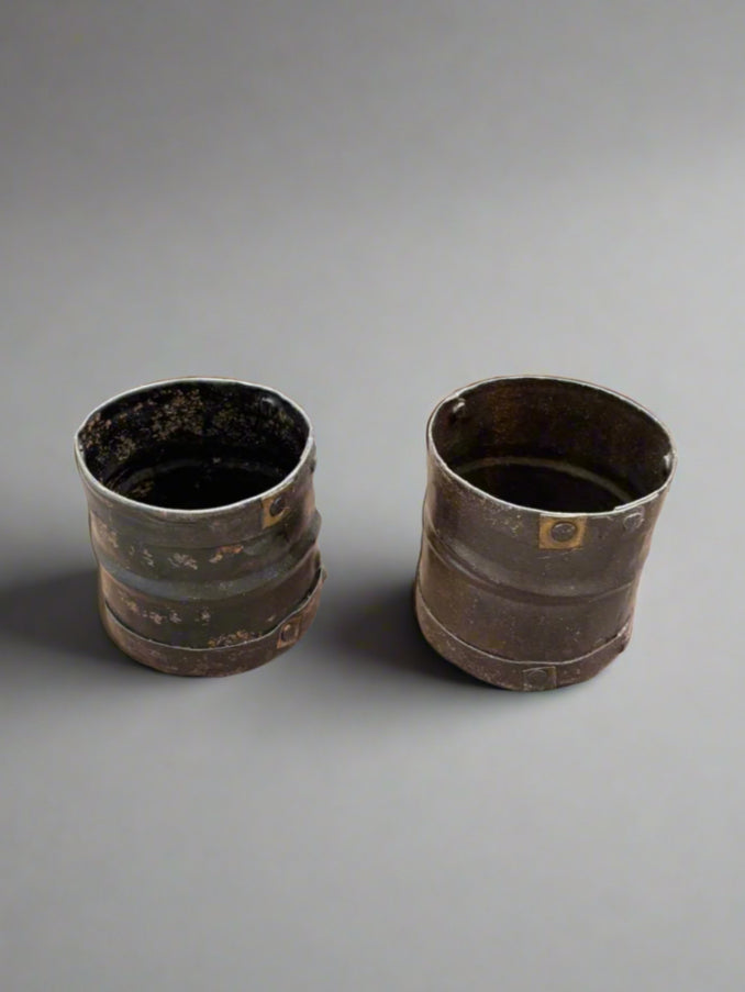 A pair of vintage metal kitchen storage pots, traditionally used in India for grain measuring.