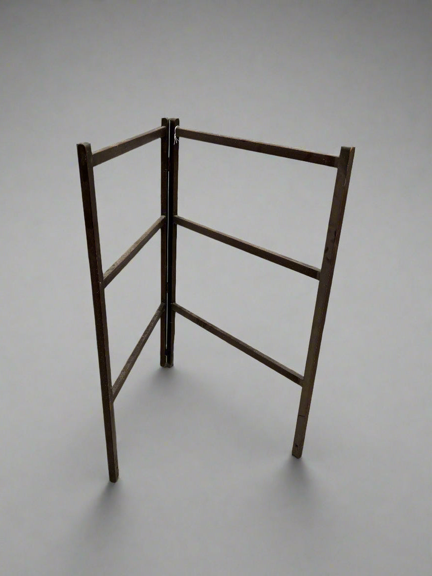 A mahogany folding clothes airer/ towel rail with six bars.