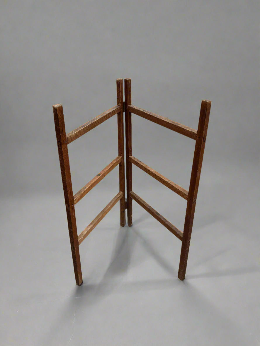 A six-bar clothes airer/ towel rack, crafted from a light coloured wood.