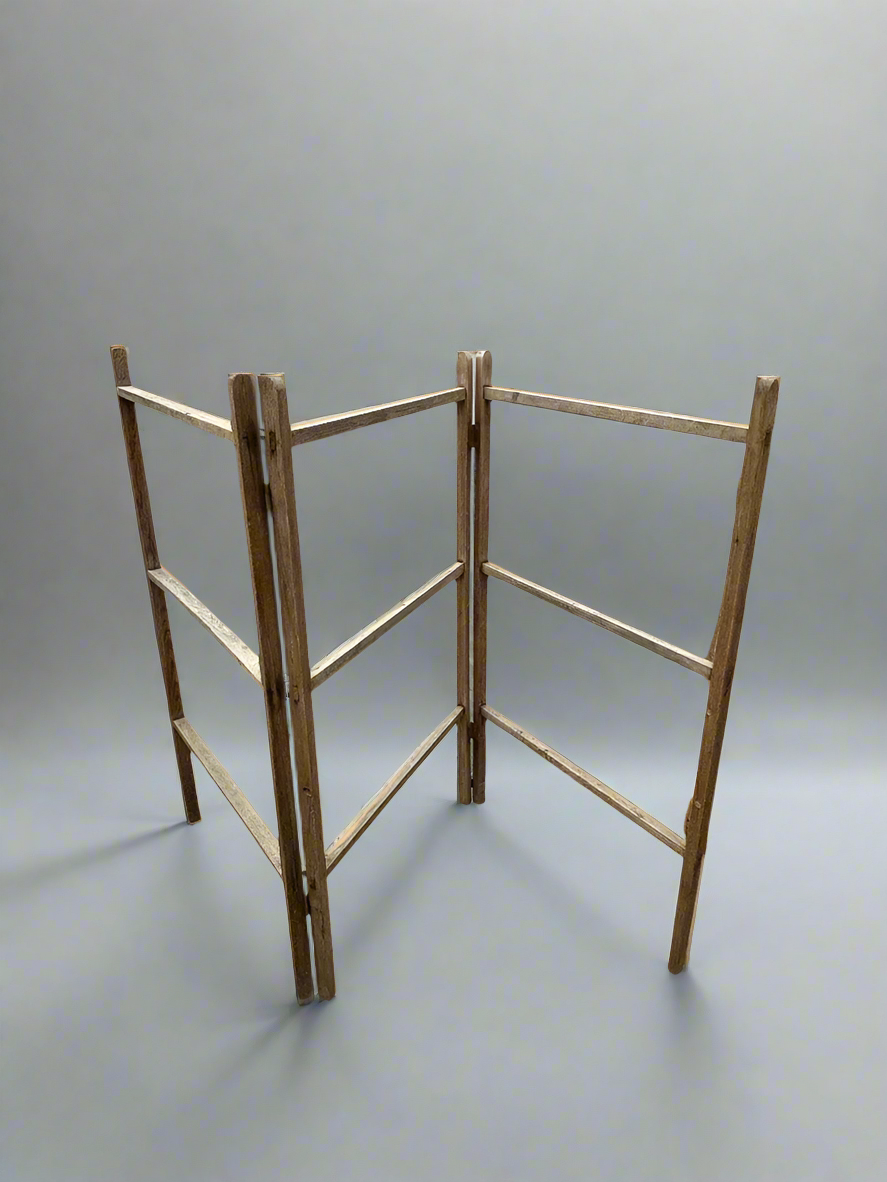 A large, wooden, folding clothes airer/ towel rail with nine bars.