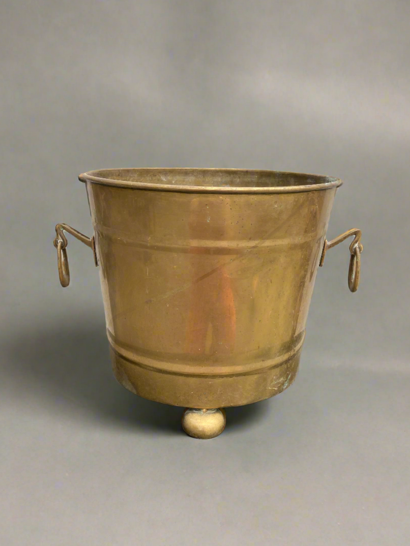An antique brass ice bucket/ wine cooler with balled feet, circa 1900s. It could also be used as a planter.