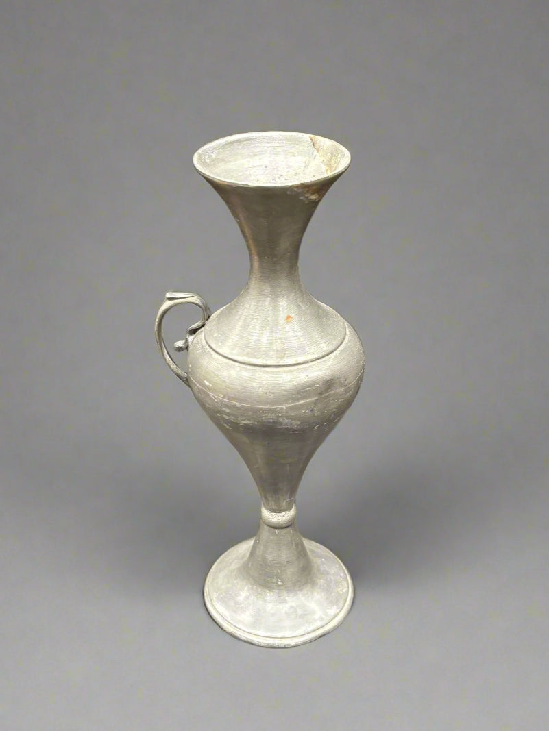 A small pewter vase/urn with a decorative handle.