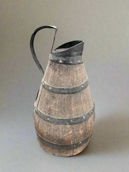 An antique French burgundy wine pitcher, circa 19th century. Crafted from wood and iron with studded banding.