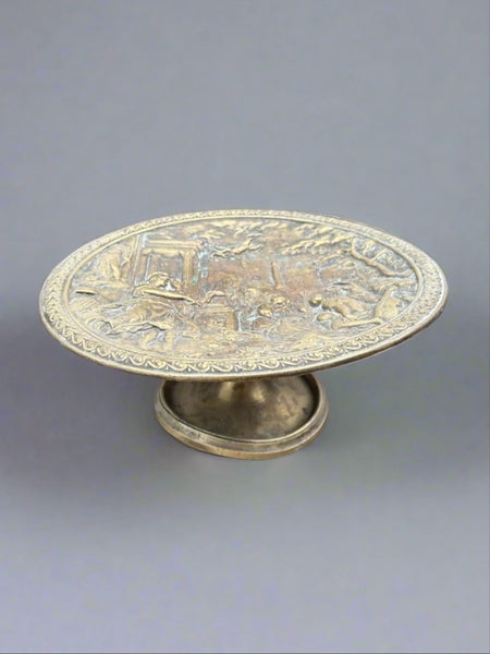 An antique brass tazza fruit plate depicting a Grecian scene, circa 19th century.