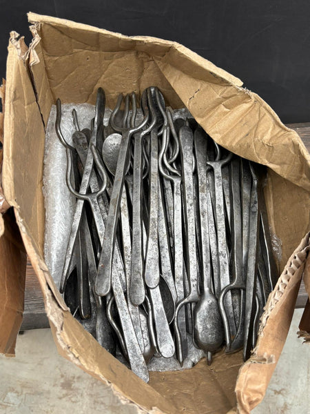 A large set of antique hand forged and hammered cutlery with long handles. The collection includes spoons and meat roasting forks.
