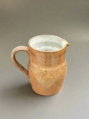 A vintage French farmhouse stoneware jug with a glazed finish.