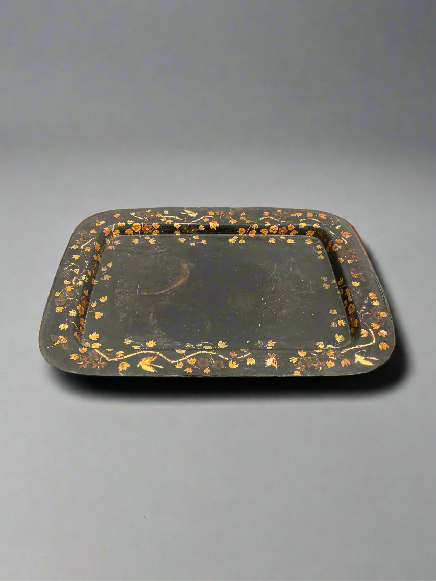 A black Victorian serving tray with toleware-style gilt flower decoration.