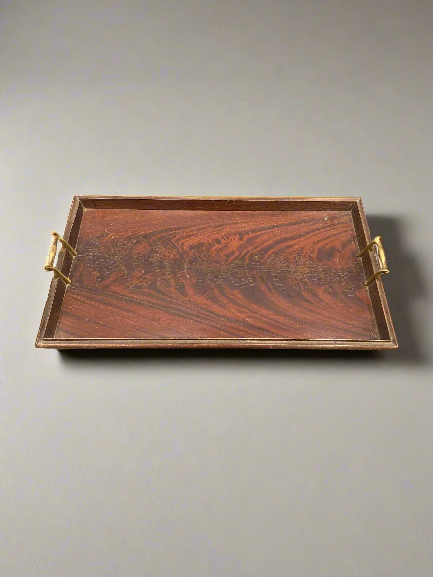 A large, rectangular, wooden, butler's serving tray with brass handles.