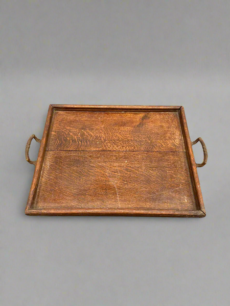An antique, oak, square serving tray with curved brass handles.
