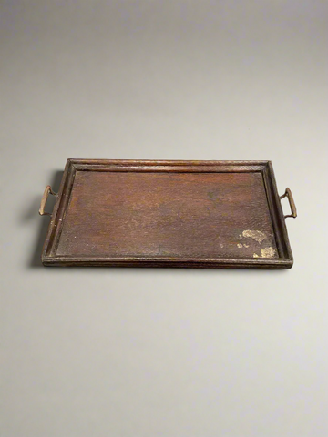 An antique, wooden, rectangular serving tray with tarnished brass handles.