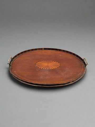 A large, antique, oval tray with an inlaid Sheraton fan centre and brass handles.