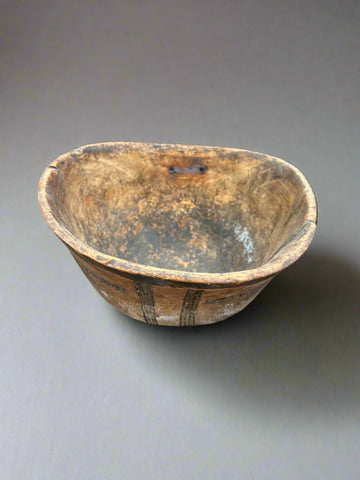 A primitive, wooden, farmhouse dough/kitchen bowl with natural markings.