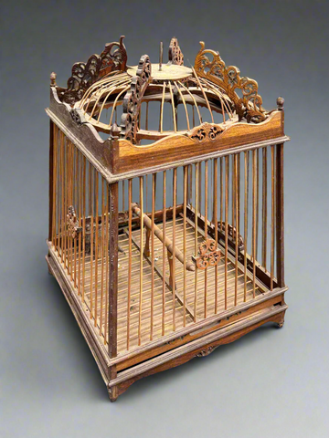 A decorative, folk, bird cage with a dome top and intricately cut wooden details.
