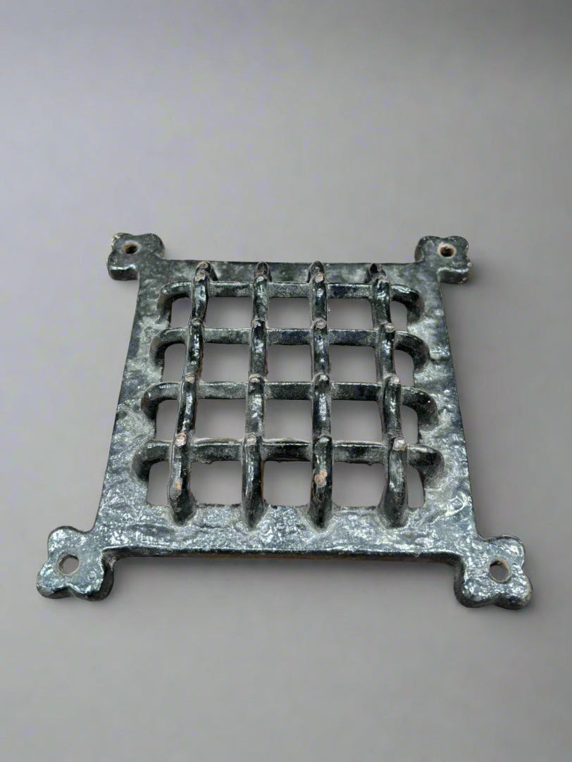 A square, medieval-style, cast iron door grill/window/aperture cover.