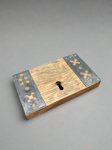 A Victorian door rim lock with decorative cast iron panels and a wooden base.