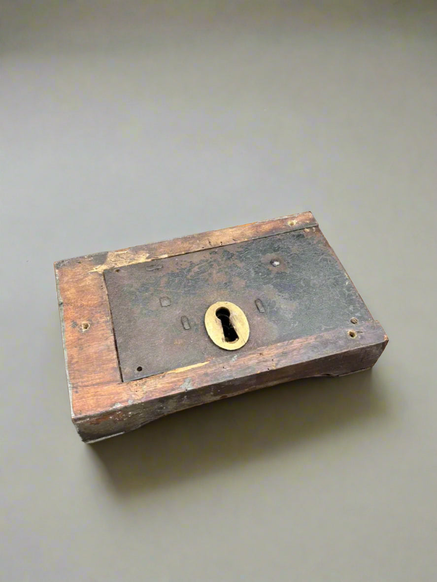 An antique, English, oak, door rim lock mechanism in an aged condition.