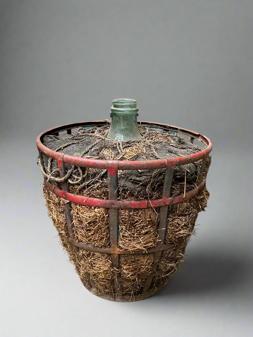 Antique French demijohn carboy bottles/ flagons in red painted metal cradles.