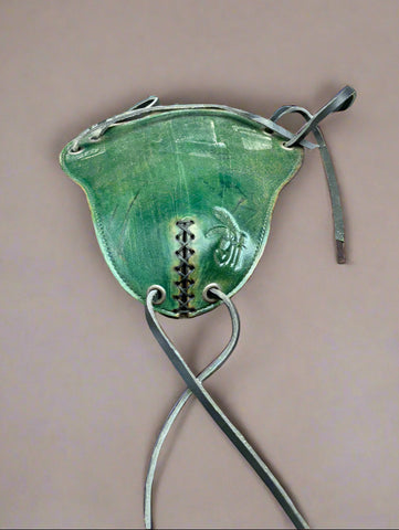 A green leather codpiece with black straps, made popular in the Tudor period.