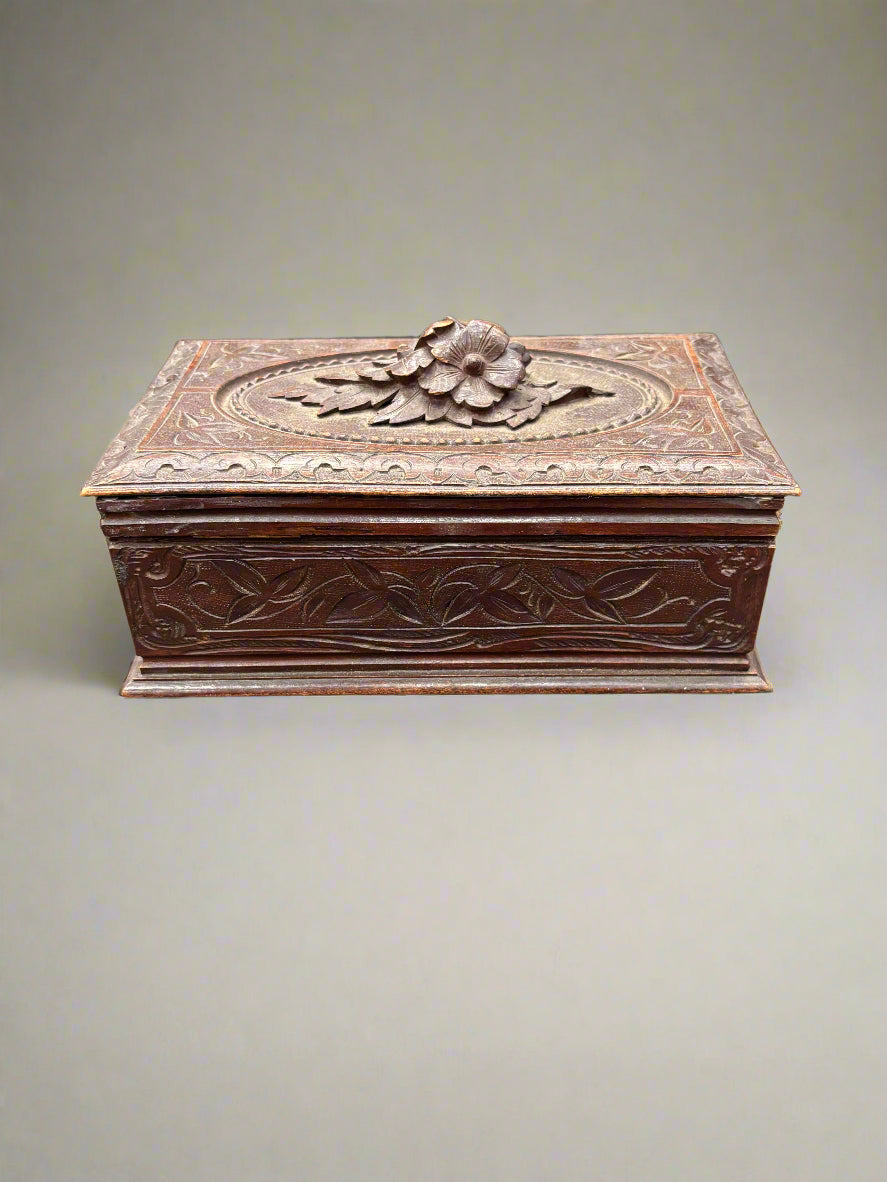 An antique handcrafted black forest storage box, topped with carved flowers- it may have originally been a humidor/ cigar or jewellery box.