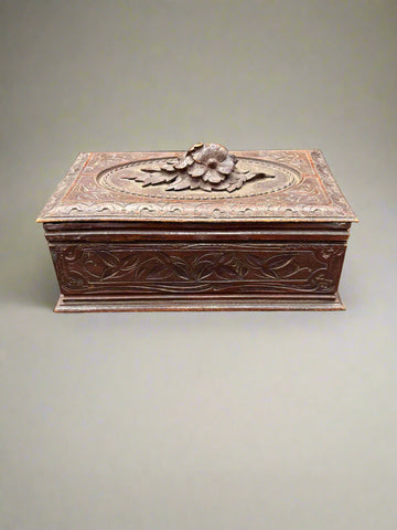 An antique handcrafted black forest storage box, topped with carved flowers- it may have originally been a humidor/ cigar or jewellery box.