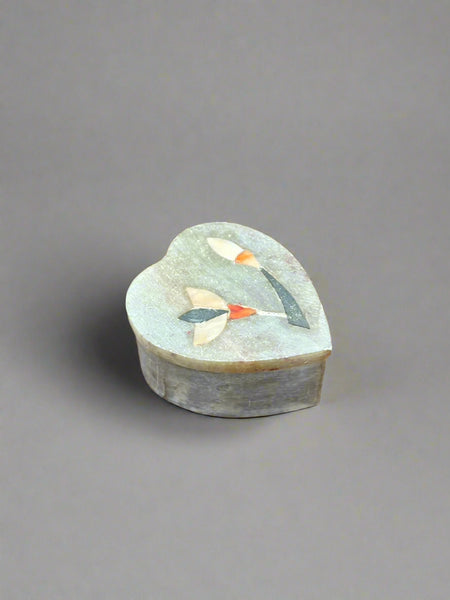A small heart-shaped soapstone box with a mother-of-pearl flower inlay.