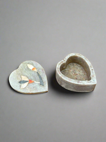 A small heart-shaped soapstone box with a mother-of-pearl flower inlay.