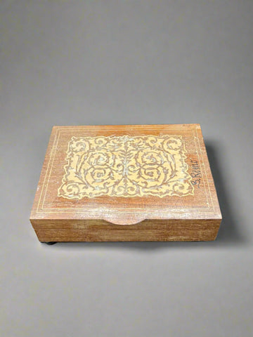 A wooden storage box with an Art Nouveau-style inlaid design on the lid.