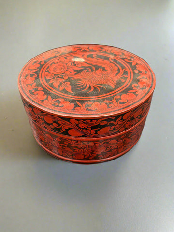 A Burmese betel nut box with a floral red and black design featuring a dragon.