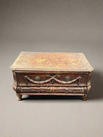 A large antique wooden deed box, with ornate black forest style carvings.