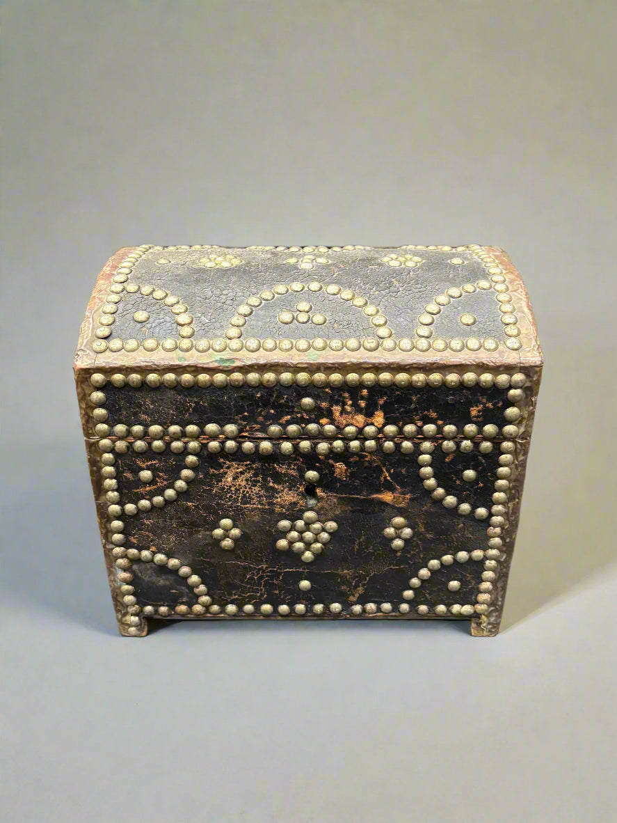 An antique leather chest box with a dome top, decorated with brass studs.