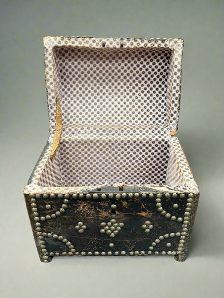 An antique leather chest box with a dome top, decorated with brass studs.