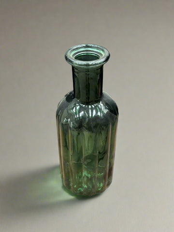 A small, ribbed, emerald green, glass bud vase.