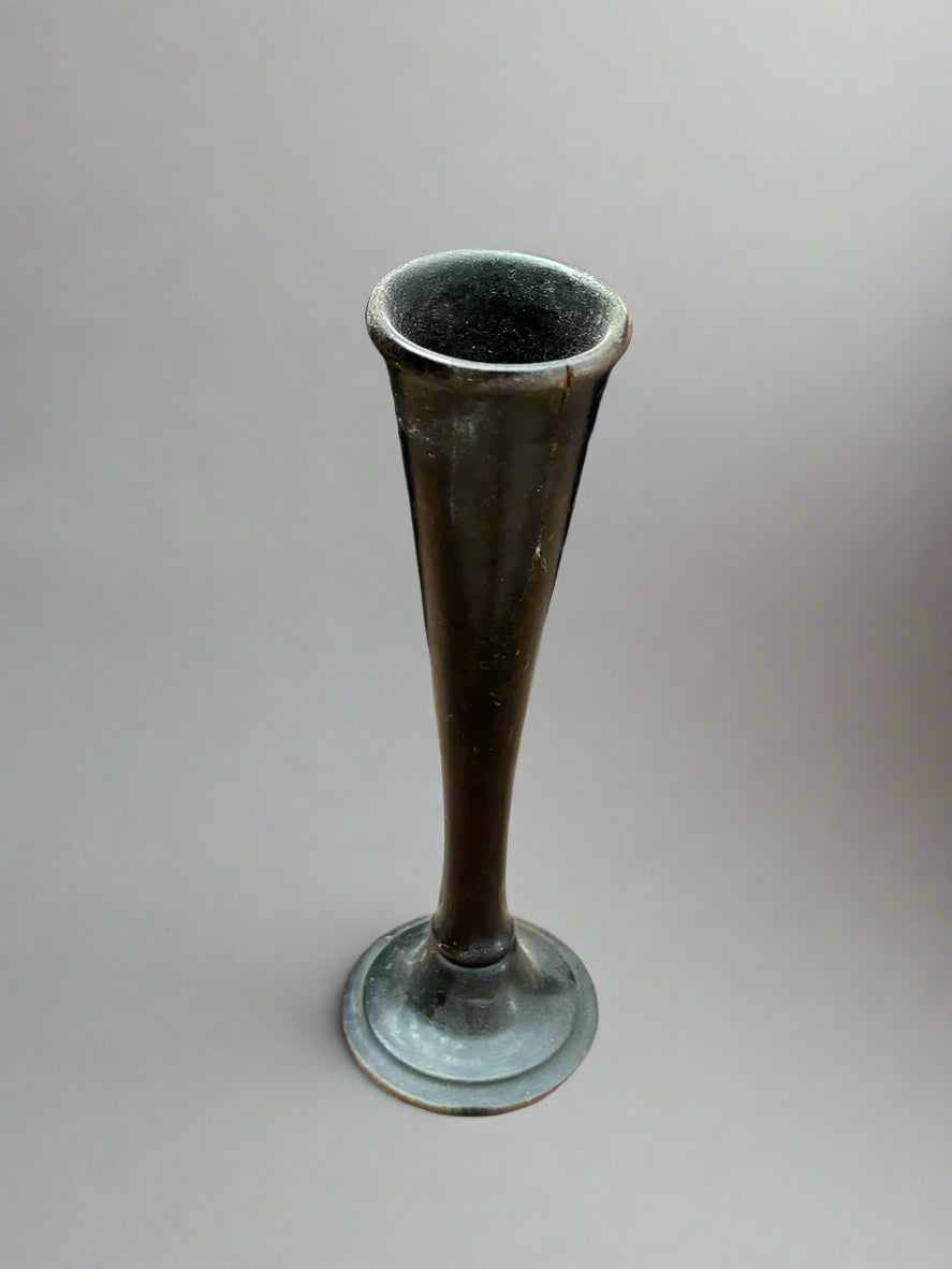 A small trumpet bud vase with a tapered stem, made from dark green glass.