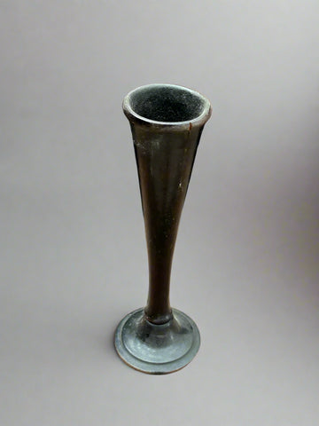 A small trumpet bud vase with a tapered stem, made from dark green glass.