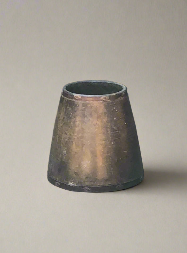 A bronze vase/planter with tapered sides.