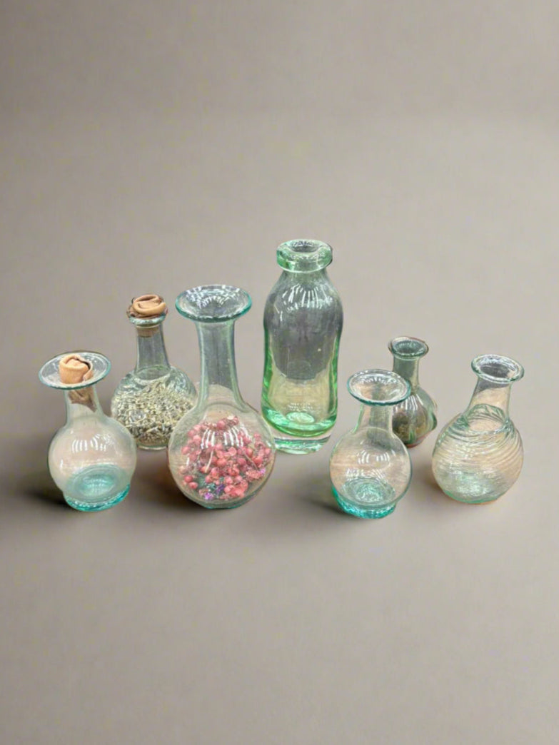 A selection of small botanic vases in various shades of green, for storing or displaying herbs, flowers or buds.