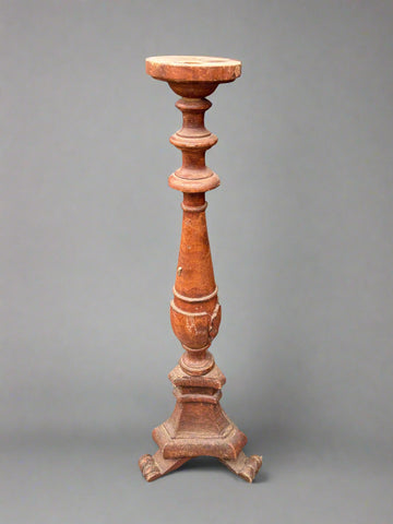 An antique, turned, torchiere pedestal with curled feet.