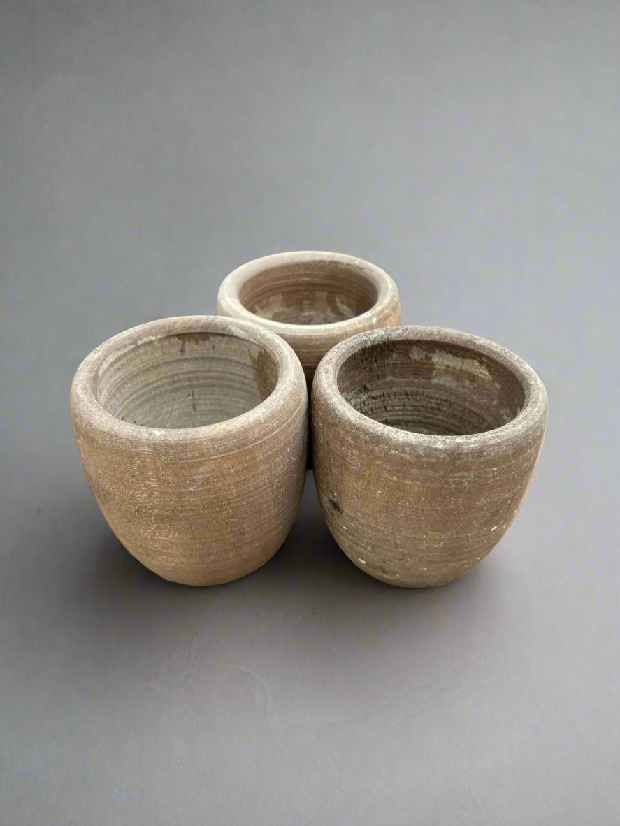 A trio of small, round, natural planters with a ridged finish.